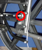 Figure 2: Location of upper axle hole with braking system attached. Upper Axle hole with 10-24 X 3" Slotted Screw marked with a red circle. 