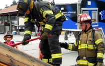 Zoom image: firefighter axing wood wall